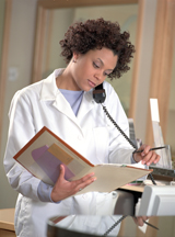Woman reads a patient chart in a healthcare setting